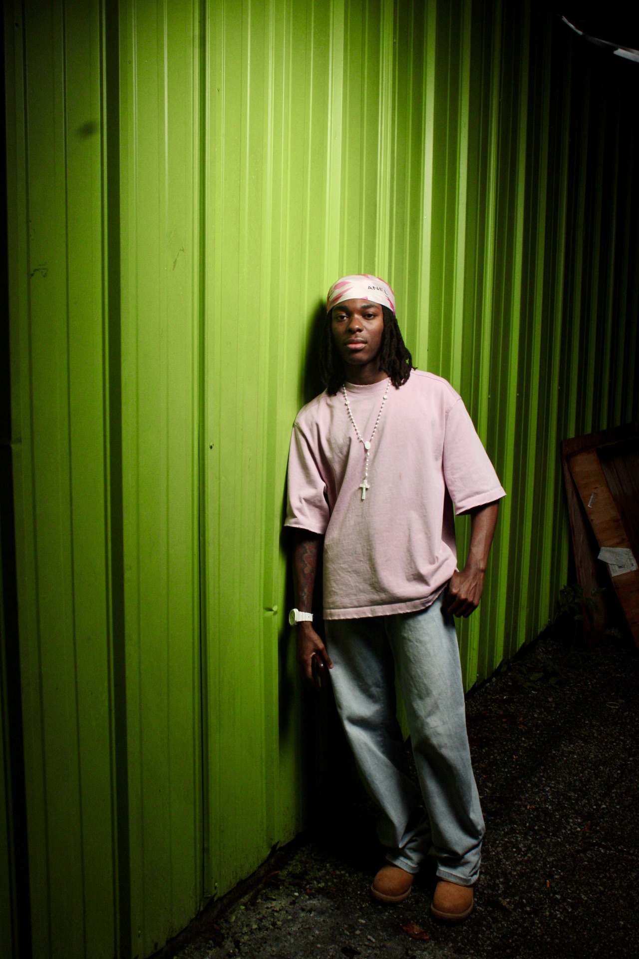 Male portrait photographed against a green wall